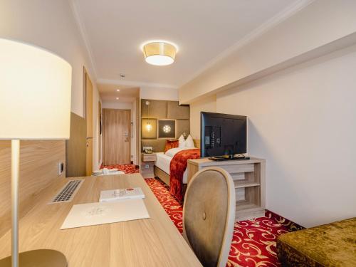 a hotel room with a bed and a flat screen tv at Hotel Norica - Thermenhotels Gastein mit dem Bademantel direkt in die Therme in Bad Hofgastein