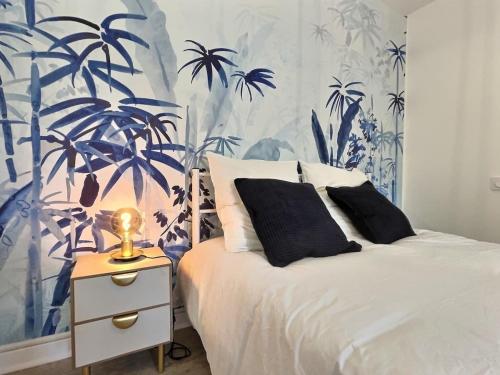 a bedroom with a bed with blue and white wallpaper at LE BLEUET - au coeur de Valence in Valence