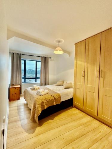 - une chambre avec un lit et une grande fenêtre dans l'établissement Wellington Central Apartment, à Waterford