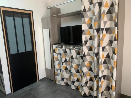 - un salon avec une télévision et un mur dans l'établissement Studio cocooning au calme au coeur de Montpellier, à Montpellier