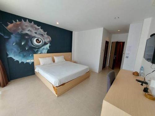 1 dormitorio con 1 cama con una pintura en la pared en GO INN Aonang Beach โกอินน์ หาดอ่าวนาง en Ban Khlong Haeng