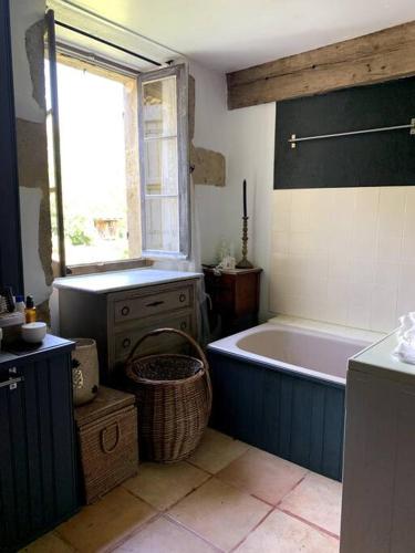 a bathroom with a blue bath tub and a window at Maison proche Marciac, 3 chambres in Armous-et-Cau