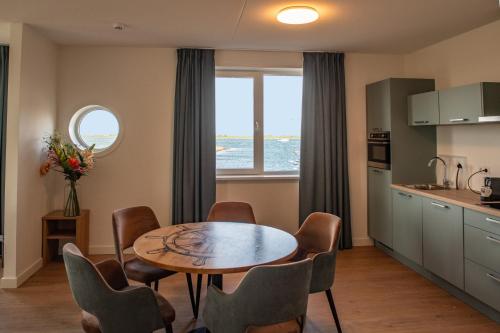 a kitchen and dining room with a table and chairs at Residentie Oosterschelde in Sint Philipsland