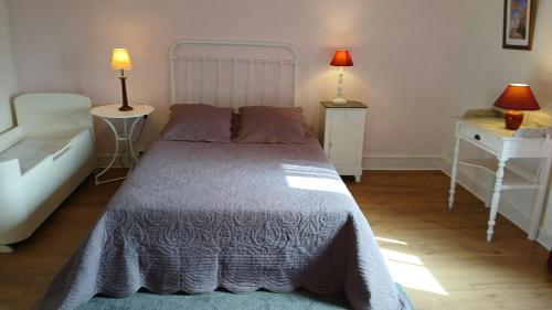 um quarto com uma cama e duas mesas e dois candeeiros em Maison de 2 chambres avec jardin clos et wifi a Martisserre em Martisserre