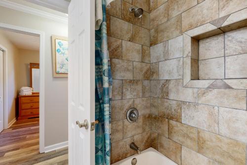 a bathroom with a shower with a tub at The Grey Pearl in Ocean Isle Beach