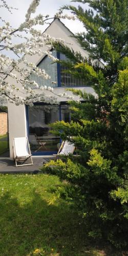 une maison avec une chaise blanche et un arbre dans l'établissement Logement entier, indépendant et au calme (2 à 4 personnes) à Cormeilles en Parisis, à 15 mn de Paris, à Cormeilles-en-Parisis
