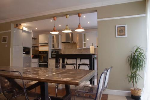 een eetkamer en een keuken met een tafel en stoelen bij Spacious & bright 4-bedroom town-house with garden in Sydenham