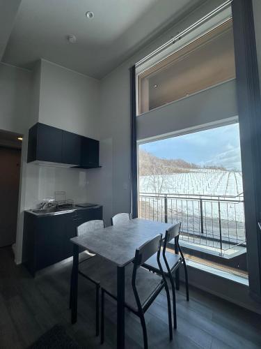 a kitchen with a table and chairs and a large window at Domaine Bless in Niki