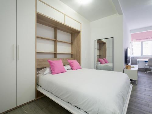 um quarto com uma grande cama branca com almofadas cor-de-rosa em Empire Canteras By CanariasGetaway em Las Palmas de Gran Canaria