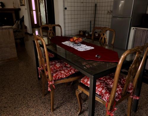 a table with chairs and a table with a bowl of fruit on it at Villa Berra - Via Postale 63/A in Berra