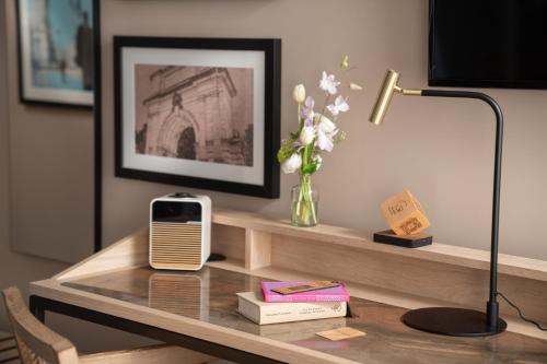a desk with a lamp and a vase of flowers at The Green in Dublin