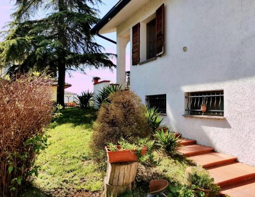 a white house with a porch and a wooden staircase at Villa Berra - Via Postale 63/A in Berra