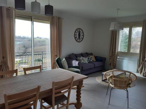 un salon avec une table, des chaises et un canapé dans l'établissement Agréable maison toute équipée, à Durfort