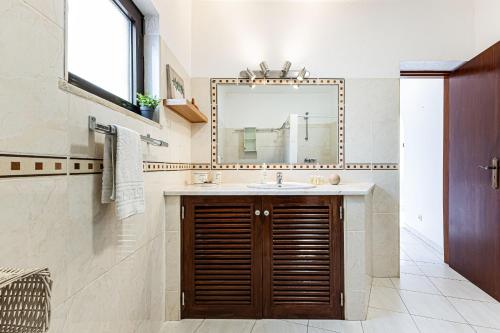 a bathroom with a sink and a mirror at Casa do Vale by Algarve Golden Properties in Porches