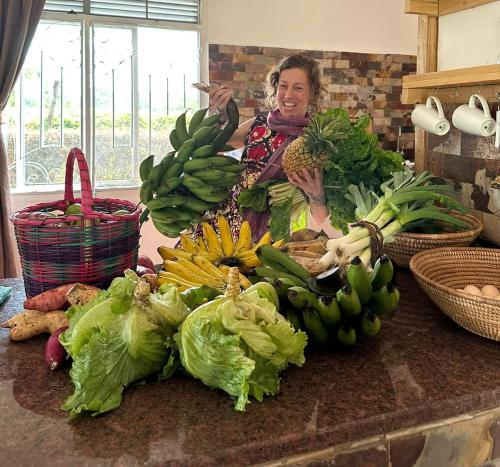 a woman standing in a kitchen with a bunch of vegetables at Kalunga Holiday Home in Banda