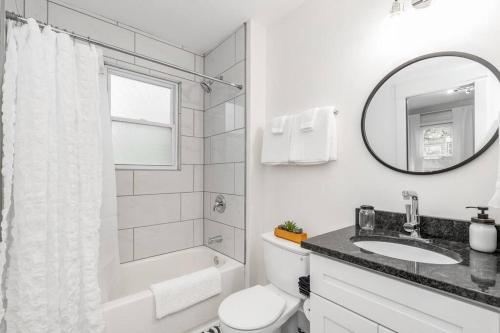 a bathroom with a toilet and a sink and a mirror at Spacious 5BR/5.5BA Near Plaza & Museum in Kansas City