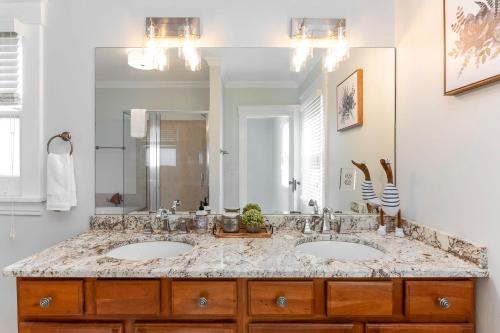 a bathroom with two sinks and a large mirror at Cincy East Side Cottage the best of Hyde Park in Cincinnati