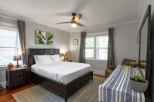 a bedroom with a large bed and a couch at Cincy East Side Cottage the best of Hyde Park in Cincinnati