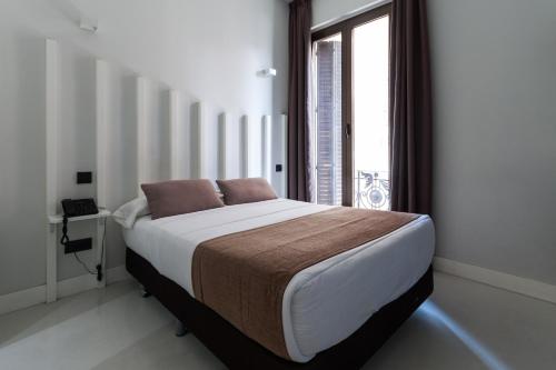 uma cama num quarto com uma grande janela em Hostal Gran Via 44 em Madri