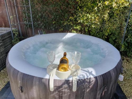 una vasca idromassaggio con una bottiglia di champagne di Sally's bed and breakfast a Luton