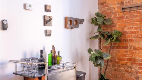 a metal cart with wine bottles and glasses on it at Central Urban Flat - Near the Best of Covington in Covington