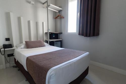uma cama num quarto com uma janela e uma cama sidx sidx em Hostal Gran Via 44 em Madri