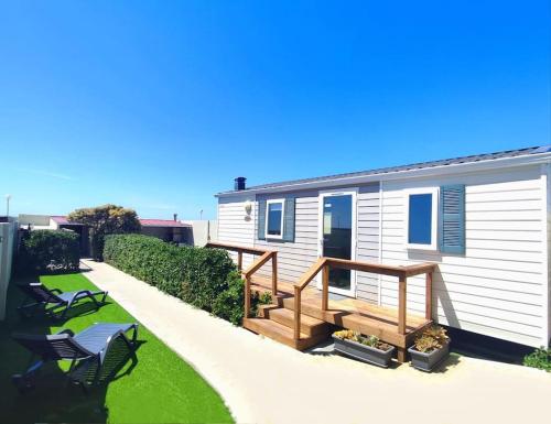a mobile home with a deck and a house at CasinhaDaPraia in Aguçadoura