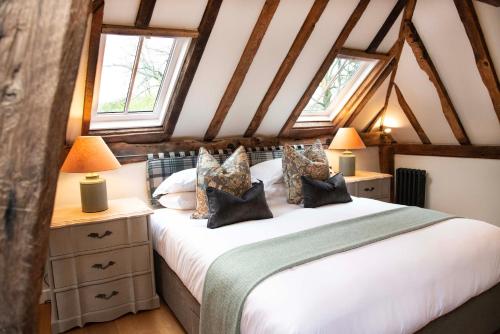 a bedroom with a bed and two windows at Mousehall Oast in Wadhurst