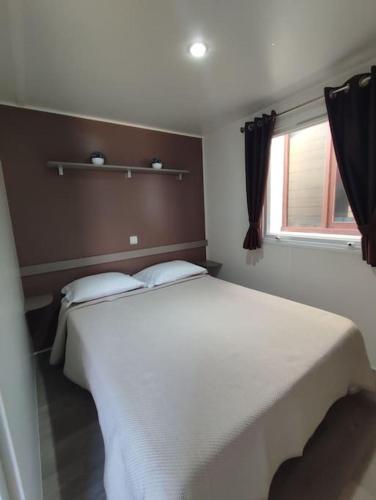 a bedroom with a large white bed and a window at CasinhaDaPraia in Aguçadoura