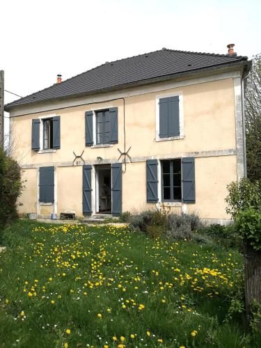 ein Haus mit schwarzen Fenstern und einem Blumenfeld in der Unterkunft Maison de famille piscine et vue in Sougères-en-Puisaye