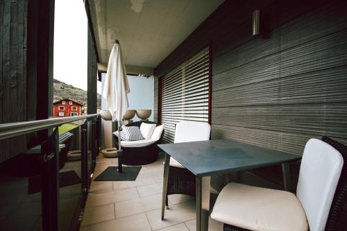 a balcony with a table and chairs and an umbrella at Haus Montanara in Unterbäch