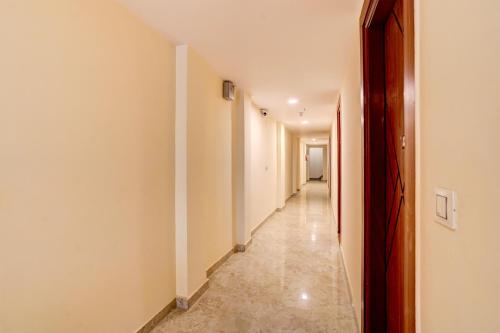 un pasillo con paredes blancas y un pasillo largo en Super OYO Flagship Red Diamond Hotel, en Ghaziabad