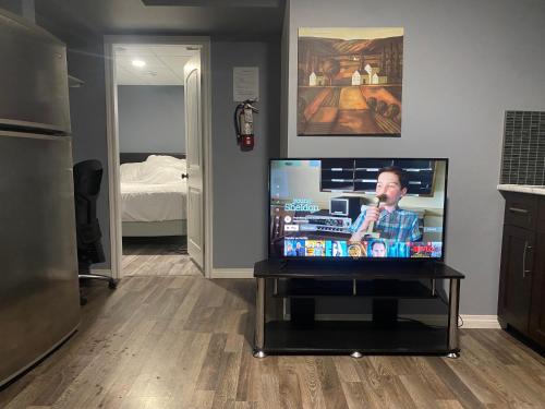 einen Flachbild-TV auf einem Tisch in einem Zimmer in der Unterkunft Cozy get-away suite in Regina