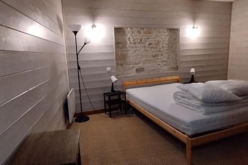 een slaapkamer met een bed, een tafel en een lamp bij Maison pour 10 personnes au centre à St Georges in Saint-Georges-dʼOléron