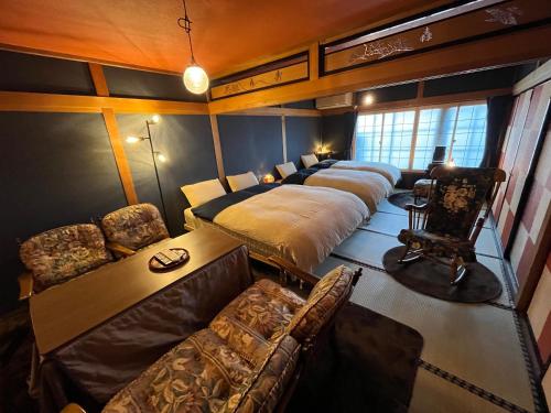 1 dormitorio con 4 camas y sofá en とれるの【TORERUNO】 en Takayama