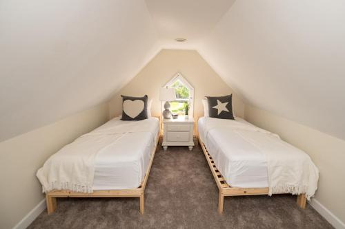 2 camas individuales en un dormitorio en el ático en The Southgate Trolley House, en Southgate