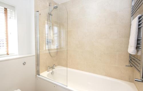 a bathroom with a shower and a bath tub at Black Lion Court in Little Walsingham