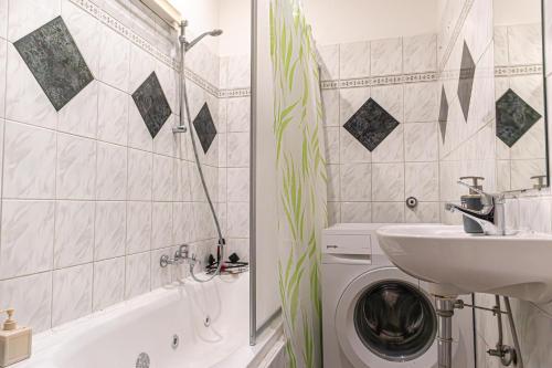 a bathroom with a washing machine and a sink at Budget Apartments Well connected to the Whole City in Vienna