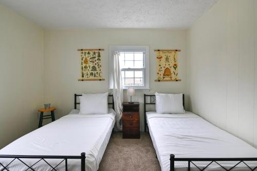 two twin beds in a room with a window at Historic Farmhouse with Pool - Sleeps 10 in Union