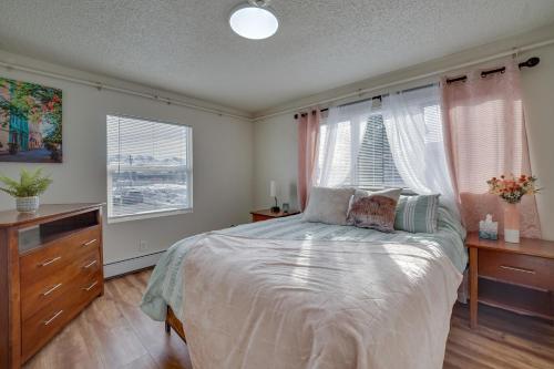 Cozy Anchorage Apartment with Mountain Views في أنكوراج: غرفة نوم بسرير وخزانة ونوافذ