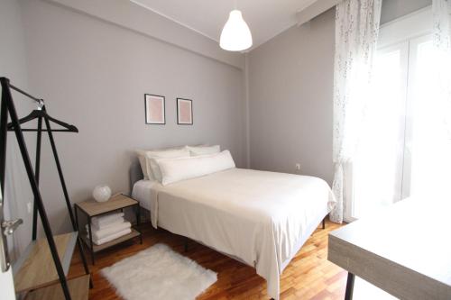 1 dormitorio con cama blanca y ventana en Newly Renovated Central 2 Bedroom Apartment in Kozani, en Kozani