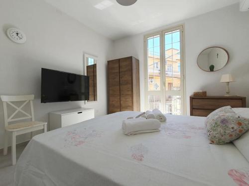 a white bedroom with a bed with towels on it at Casa Svea in Avola