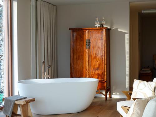 a white bath tub in a room with a wooden cabinet at Villa La Verdoyante in Lierneux