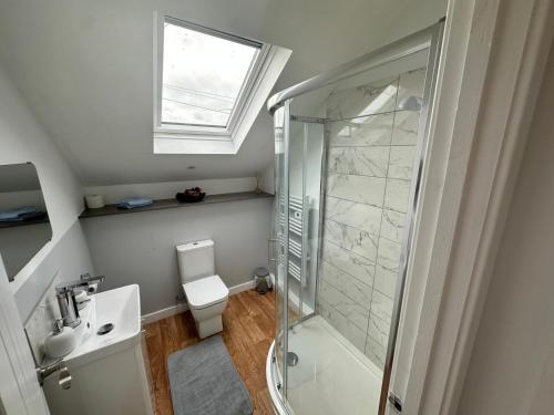 uma casa de banho com um chuveiro, um WC e um lavatório. em Tankerton Beach Daze em Kent