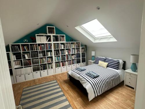 a bedroom with a bed and bookshelves filled with books at Tankerton Beach Daze in Kent