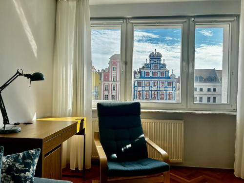 Zimmer mit einem Schreibtisch und einem Stuhl vor einem Fenster in der Unterkunft Old Town 2-Bedroom Apartment Sienny Market Square by Stayly in Stettin