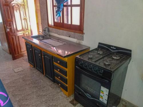 a kitchen with a stove and a sink in it at LA TRANQUERA DPTOs in Río Cuarto