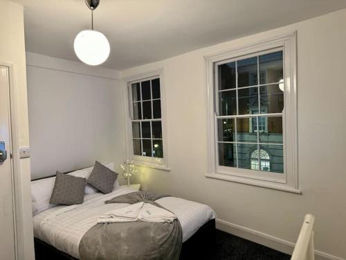 a bedroom with a bed and two windows at Room 4 • Double Bed in King’s Cross in London