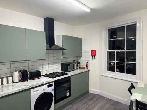 a kitchen with a stove top oven next to a window at Room 4 • Double Bed in King’s Cross in London