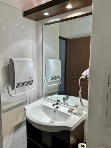 une salle de bain avec un lavabo et un miroir dans l'établissement Hôtel Restaurant Les Jasses de Camargue, à Gallargues-le-Montueux